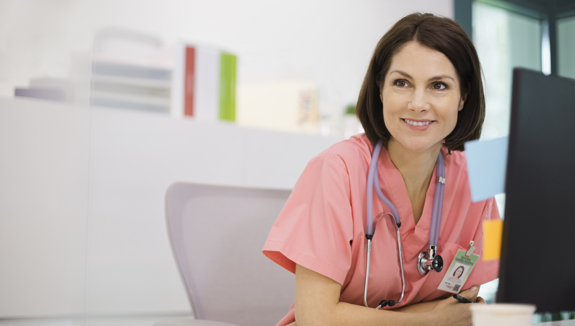 clinician-at-desk-with-laptop-Hollister-CeraPlus-skin-barrier-case-studies-575x325